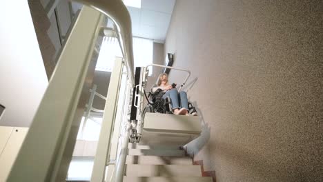 una niña en silla de ruedas sube las escaleras sin esfuerzo usando un ascensor de escaleras.