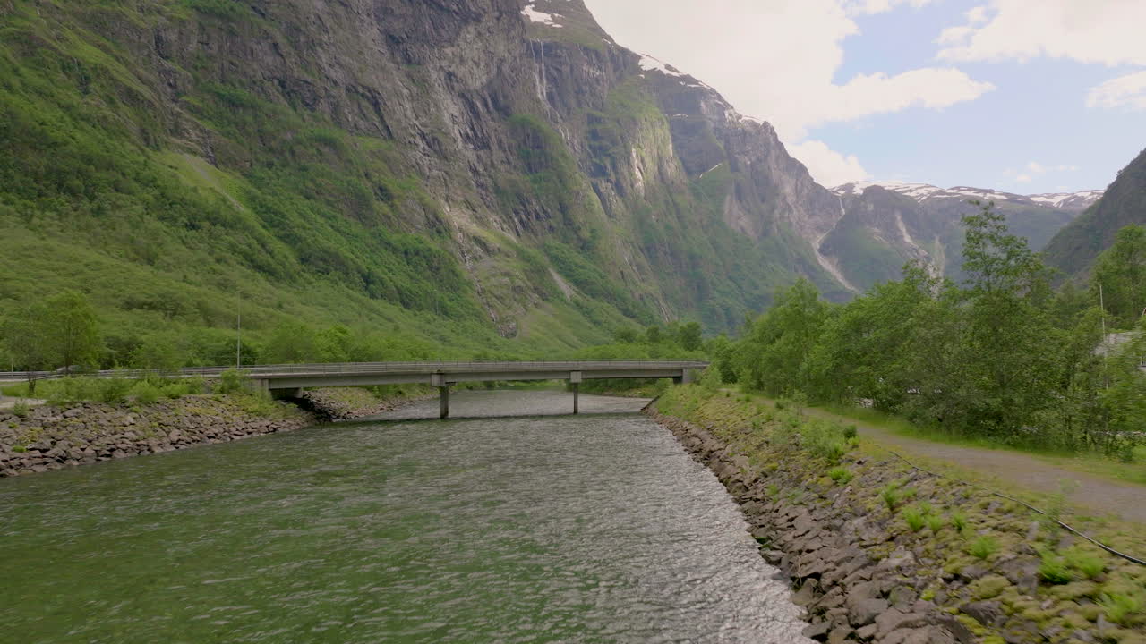 puente sobre el arroyo en gudvangen durante el día con una montaña escénica en aurland, vestland, noruega