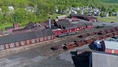 An-Aerial-View-of-an-Abandoned-Narrow-Gauge-Coal-Rail-Road-with-Rusting-Hoppers-and-Freight-Cars-and-Support-Building-Starting-to-be-Restored