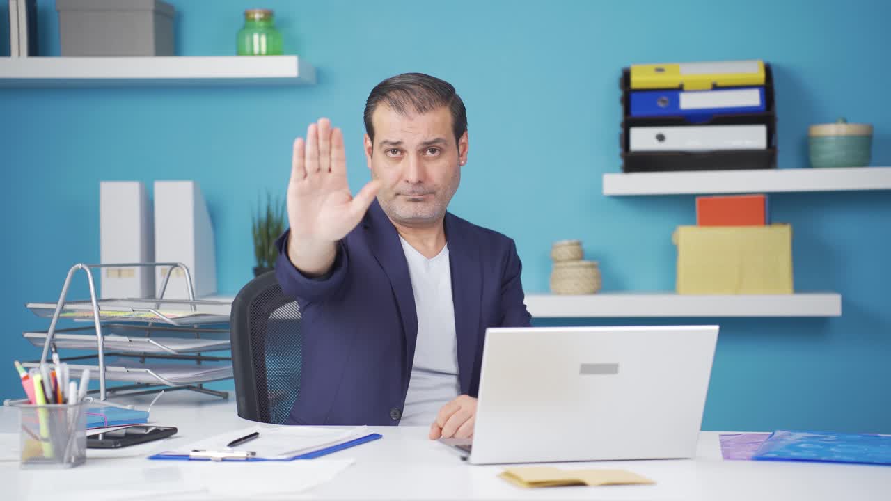 un hombre de negocios dice "deténgase" a la cámara.