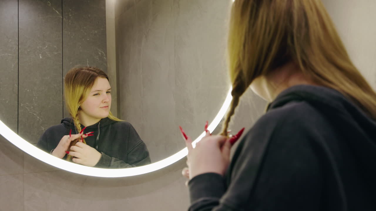 Donna che si intreccia i capelli in bagno