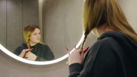 woman braiding hair in bathroom