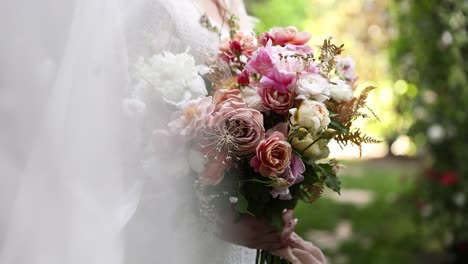 beautiful bride in wedding dress holding colorful floral bouquet, close-up