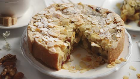 whole delicious apple cake with almonds served on wooden table