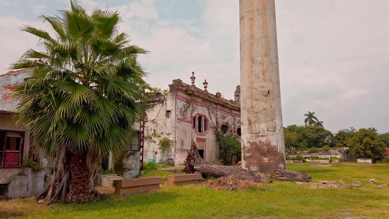 Rovine storiche di un'hacienda circondate da palme, prati erbosi e strutture architettoniche logore a Morelos, Messico, che mostrano l'eredità coloniale e un'atmosfera rustica