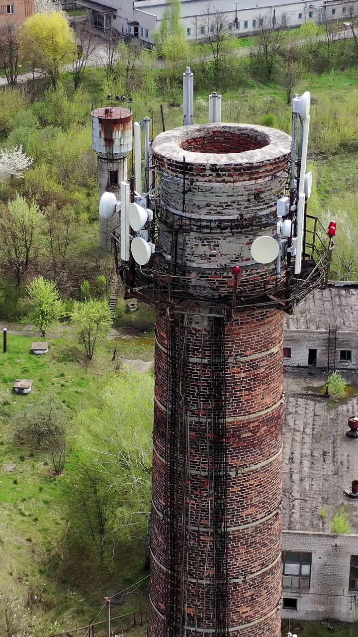 Aerial view of abandoned ruined factory tube. Apocalypsis crashed city. Vertical video