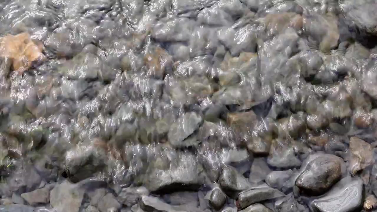 Clear water lapping over pebbles on the shore of Bala Lake, Wales. UK