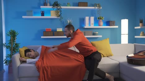 loyal and loving young man covers his sleeping little brother with a blanket.