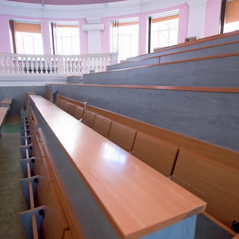 rows of long desks in conference hall. empty auditorium in the modern educational center. wooden tables without students in large comfortable classroom