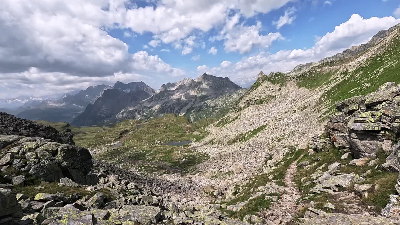 Rocky mountain trail at Passo di Valtendra with a sweeping view of Punta d’Aurona and the Alpe Veglia region