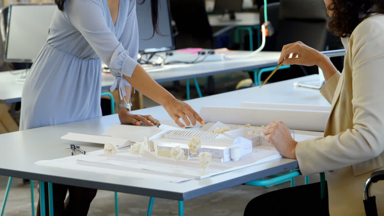 4k 사무실에서 건축 모델에 대해 논의하는 임원들