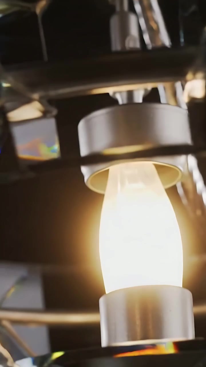 Vertical video: Starting pan, camera moving canopy to bulb in studio, showing prism refractions