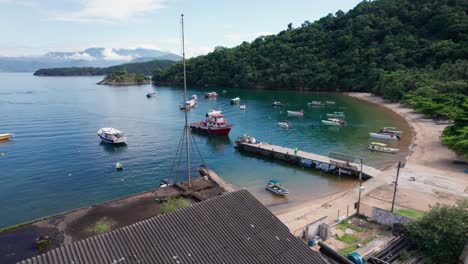 Toma-Aérea-Del-Bote-De-Basura-Que-Llega-A-La-Costa-De-La-Isla-De-Ilha-Grande-Para-Recoger-Basura,-Brasil