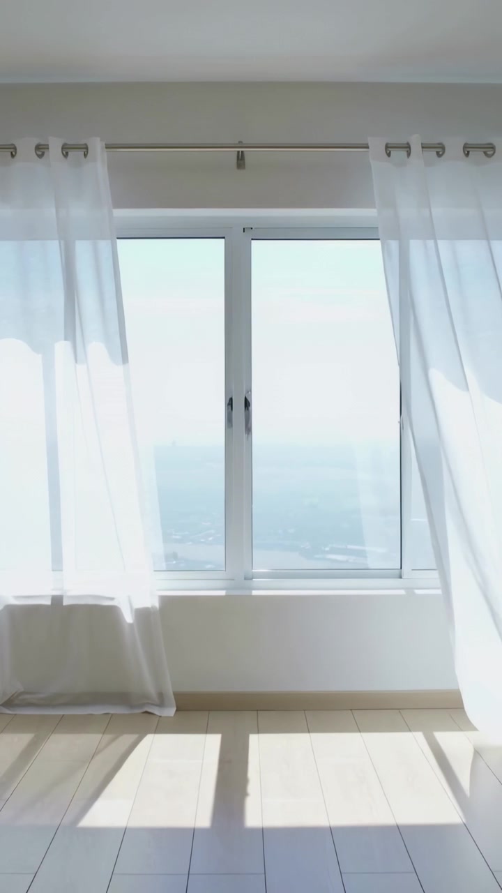 Vertical video: Gust causing sheer curtains billowing in bright room, latch shown, sun patch moving