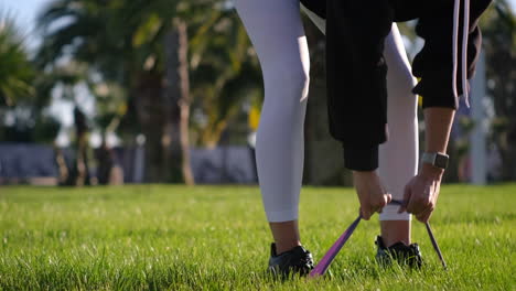 woman doing resistance band exercise in a park