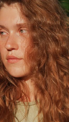 close-up portrait of a young woman with red curly hair