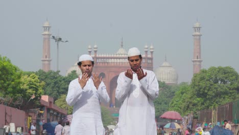 muslim men praying in front of a jama masjid delhi india