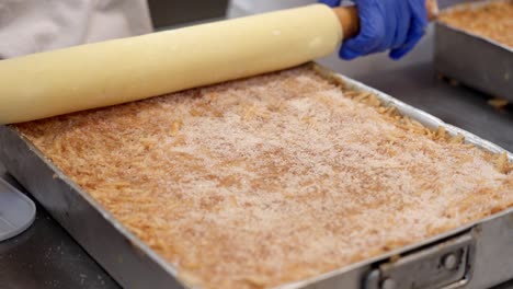 dough rolled over layers of filling in a baking tray