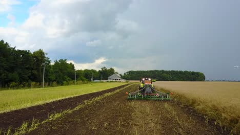 tractor preparing land. farmer in tractor preparing land with seedbed cultivator
