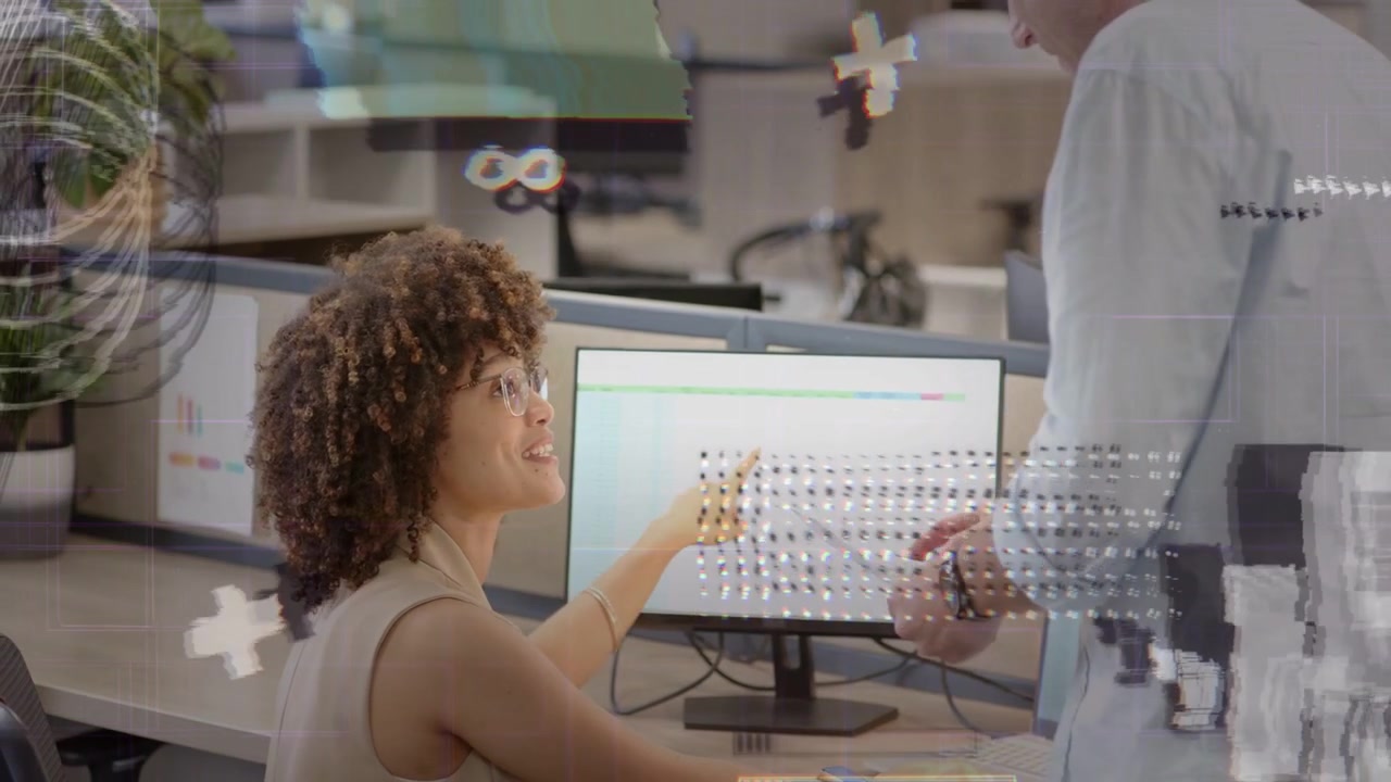 Woman pointing at monitor, man entering and exchanging file, clarifying office work with graphics