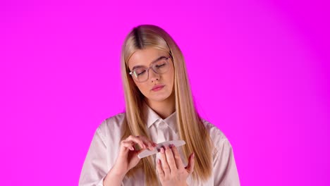 Close-up-blonde-woman-treating-herself-with-filing-fingernails,-doing-manicure