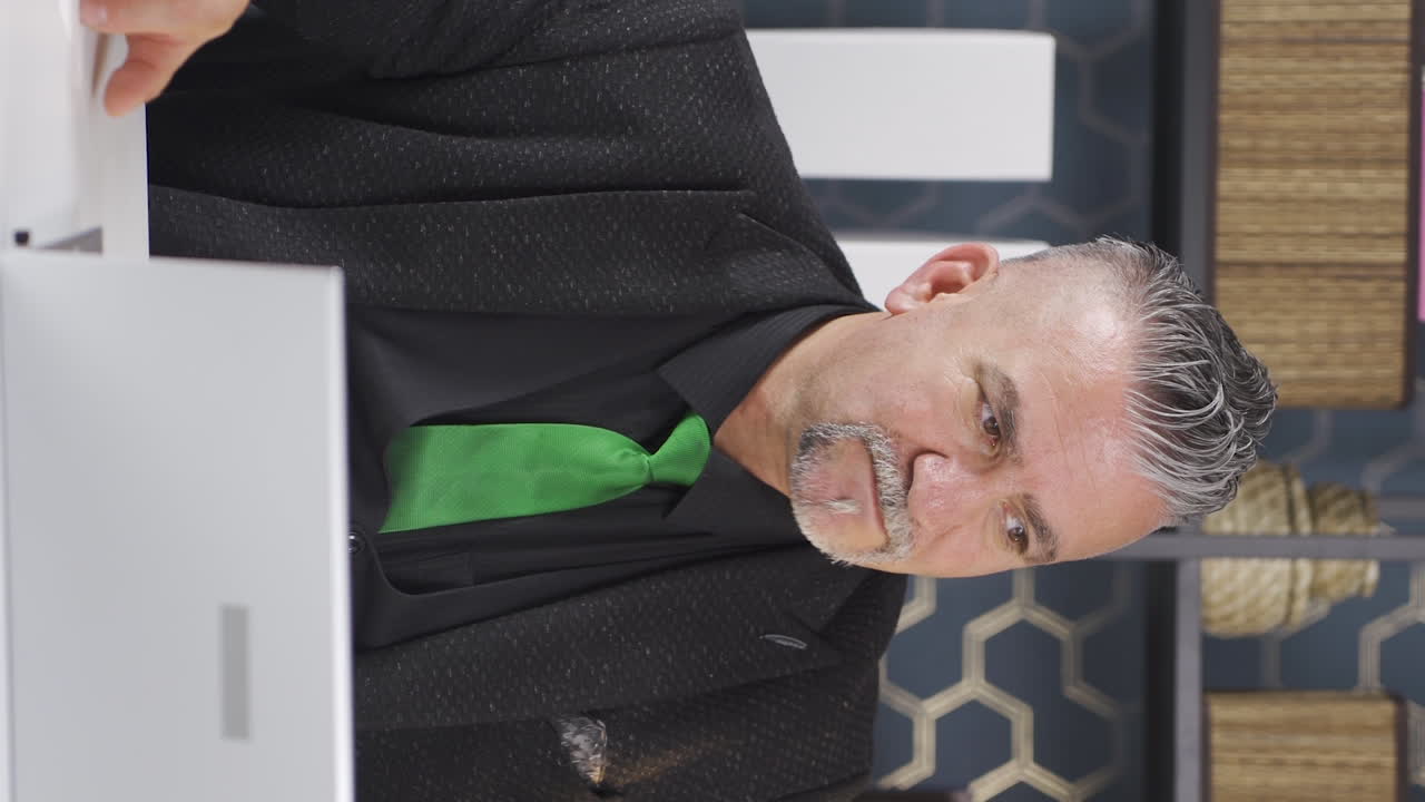 책상에서 긴장하고 스트레스를 받는 사업가의 수직 비디오.