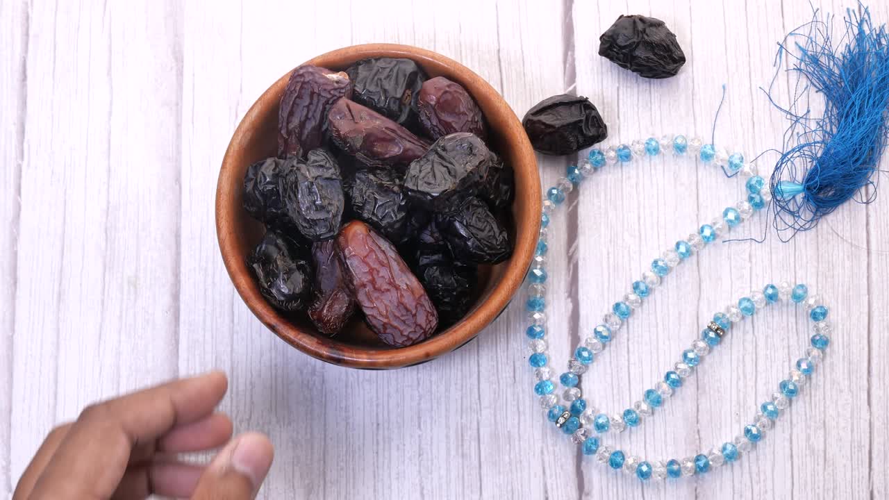 Hands of a man taking dates fruit in the plate