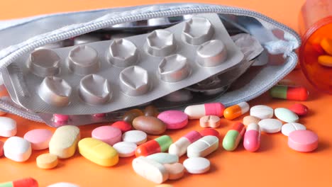 close-up view of various pills and capsules spilled from a medicine pouch and a pill bottle