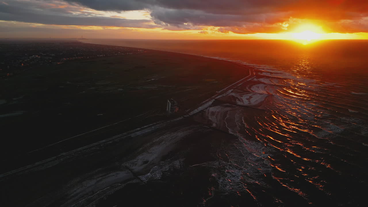 puesta de sol sobre ondas de cámara lenta en rossall point en invierno