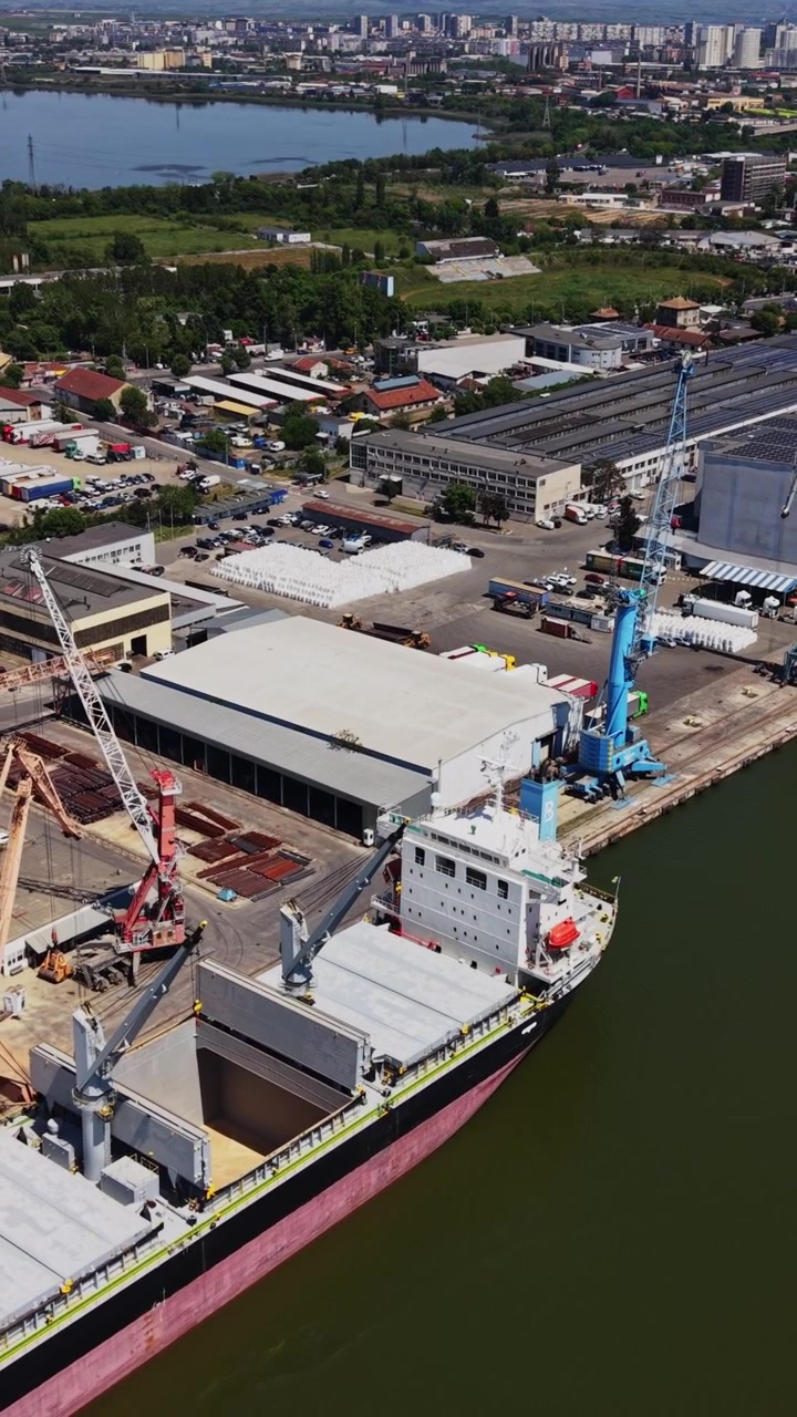 Navi da carico e container al porto in un'area industriale vicino all'acqua.