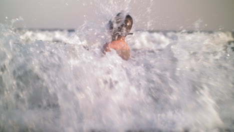 child bathing in the sea and waves hit him