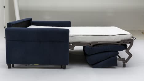 Side-profile-of-blue-fabric-pull-out-sofa-in-a-photography-studio