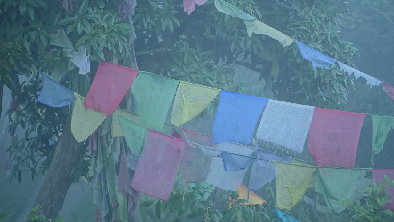Misty Blue Buddhist Prayer Flags in Nepal, Religious Prayer Flags in Mist and Nature in Forest Scenery Landscape in Foggy Moody Blue Atmospheric Mood Scene in the Himalayas in Tranquil Peaceful Scene