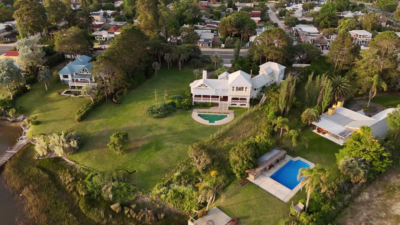 Aerial view of luxury villa with swimming pool in noble neighborhood of Punta del Este, Uruguay. Top down shot. Ocean view and large property. Fancy mansion in autumn season.