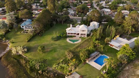aerial view of luxury villa with swimming pool in noble neighborhood of punta del este, uruguay. top down shot. ocean view and large property. fancy mansion in autumn season.