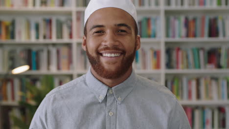 young confident middle eastern man standing in library looking smiling portrait of proud entrepreneur