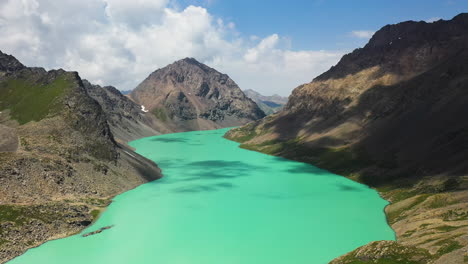 Slow-rotating-drone-shot-of-the-Ala-Kol-lake-and-its-surrounding-mountains-in-Kyrgyzstan