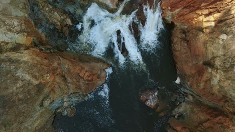 aerial view of foaming water between rocks