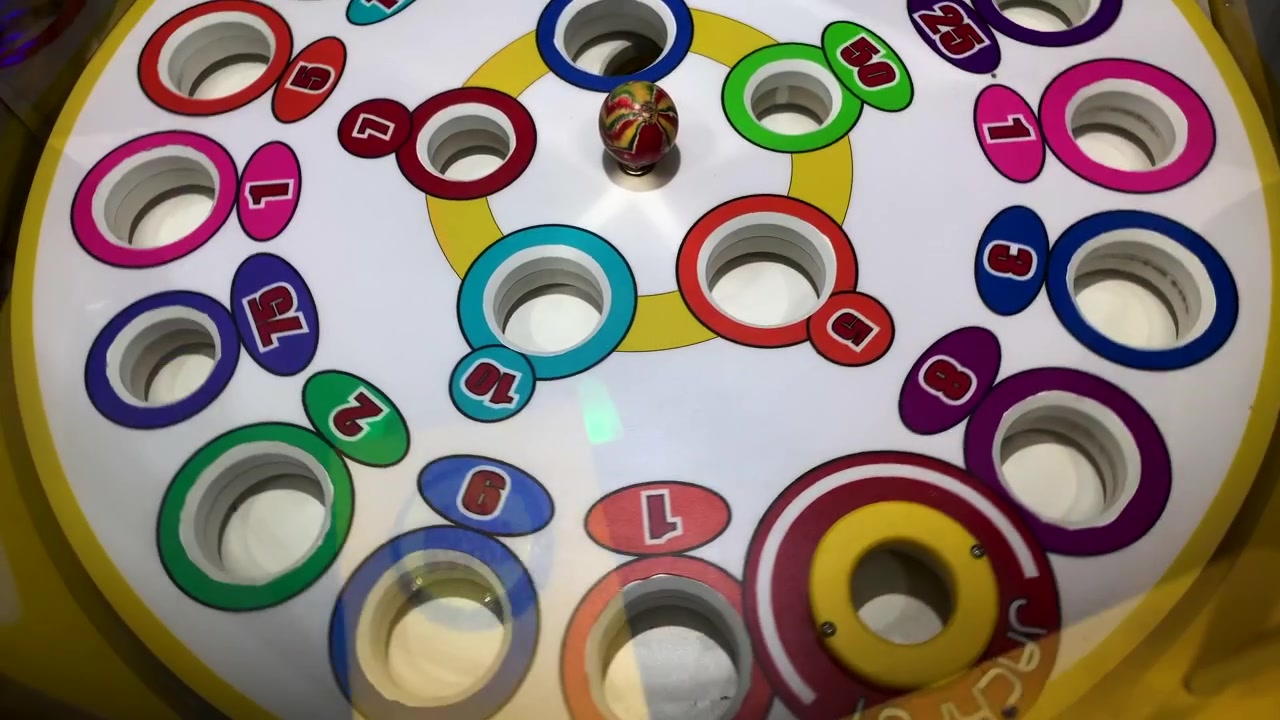 Vue aérienne d'une roue de roulette en rotation avec des chiffres colorés.