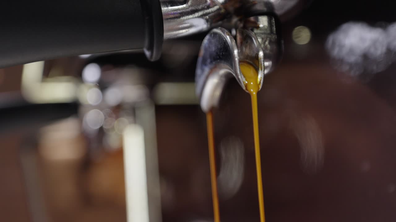 Close up of fresh espresso flowing from Italian steal coffee machine