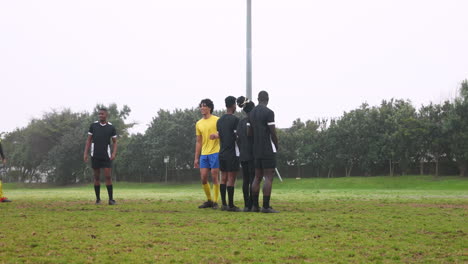 playing soccer, team huddling on field discussing strategy during match