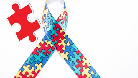 animación de piezas de rompecabezas rojas y amarillas que caen sobre la cinta de concienciación sobre el autismo formada con rompecabezas