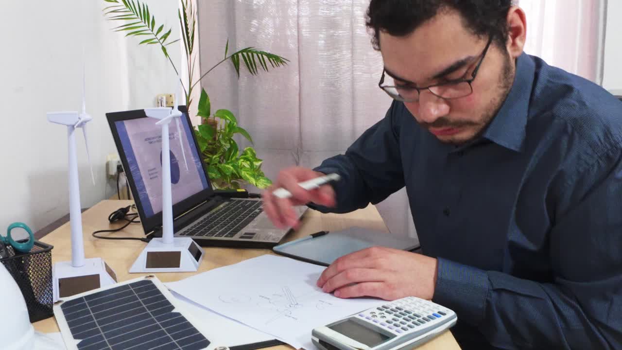 Ingeniero ultimando los planos y cálculos para un proyecto de energía verde