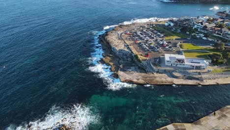 Vista-De-Pájaro-Del-Parque-De-Automóviles-Y-Bicicletas-En-La-Costa-Rocosa-De-La-Playa-Clovelly-En-La-Ciudad-De-Sydney,-Australia