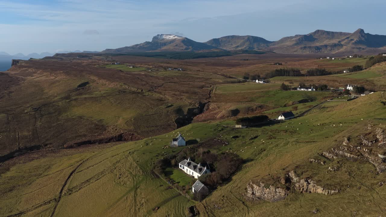 Hvitt gårdshus og grønne jorder på Isle of Skye, Skottland