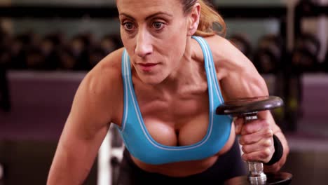 fit woman lifting dumbbells at crossfit session