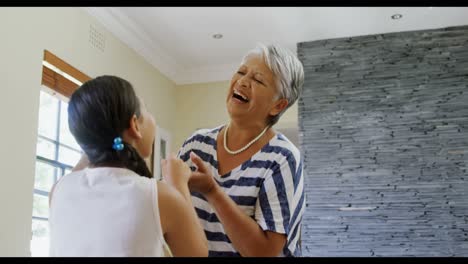 Grandmother-and-granddaughter-dancing-in-living-room-4k