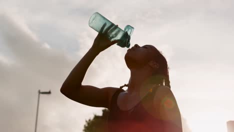 Low-Angle-Ansicht-Einer-Jungen-Afroamerikanischen-Frau,-Die-Wasser-In-Der-Stadt-4k-Trinkt
