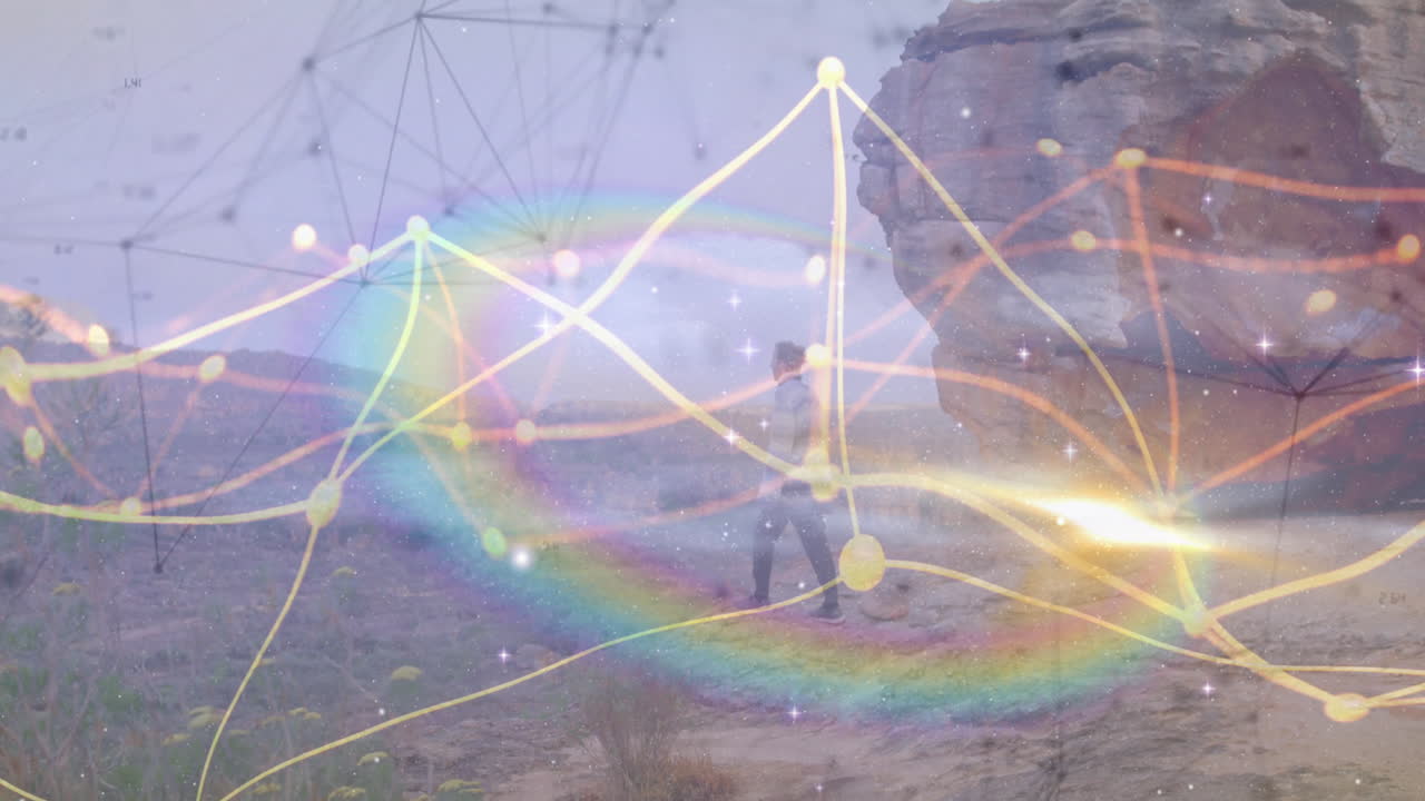 Man standing on desert plateau by rock formation, exploring technology overlay with network lines