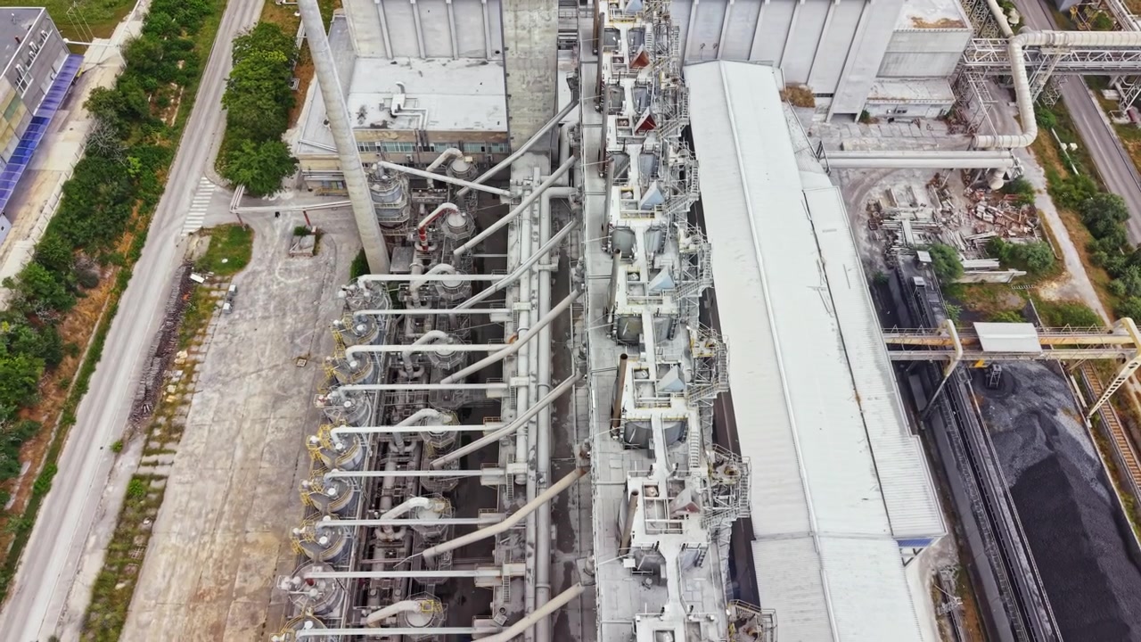 View of industrial plant with machinery and pipes during daytime in an urban area